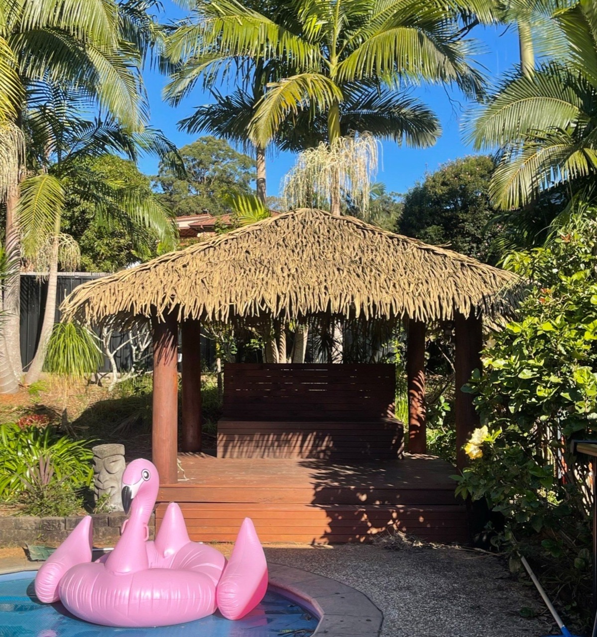 Poolside Alang Alang Bali hut surrounded by palms — a backyard escape by Tropical Gazebos