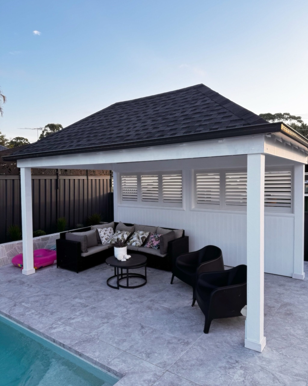 Modern Colorbond gazebo beside a pool at dusk