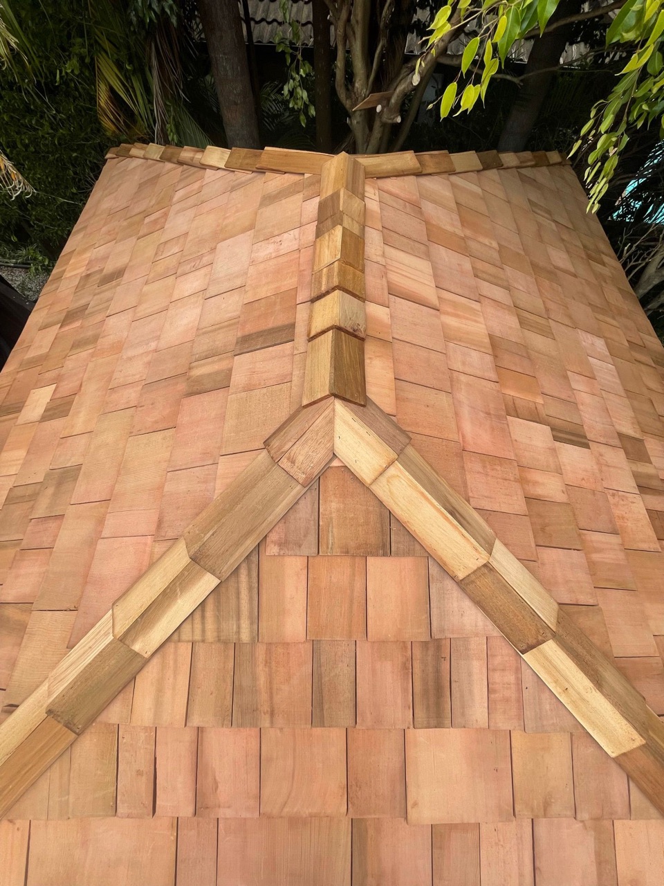 Close-up of a thatched and shingle roof apex